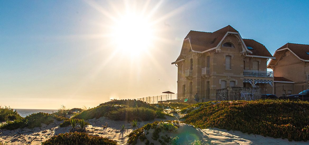 Grandes bibliothèque au bord de la Plage Sud de Biscarrosse sous un soleil éclatant, entourées de dunes de sable et de végétation côtière.