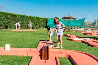 Une famille et des amis jouent au mini-golf au camping