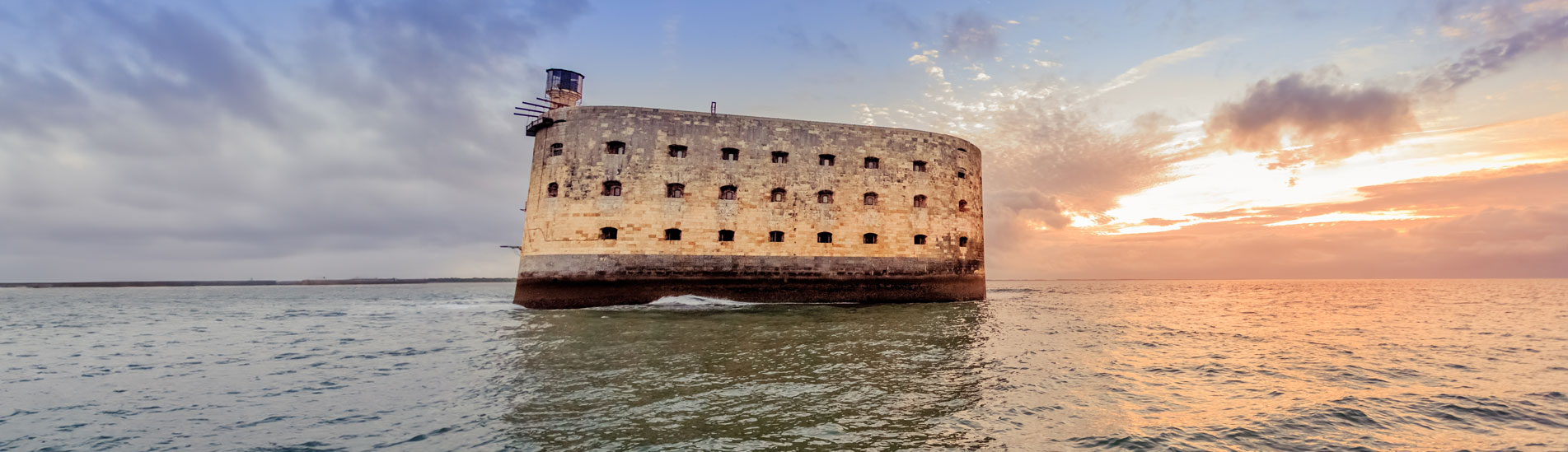 Le Fort Boyard, une forteresse en mer au large de la côte ouest de la France, baignée par la lumière du coucher de soleil.